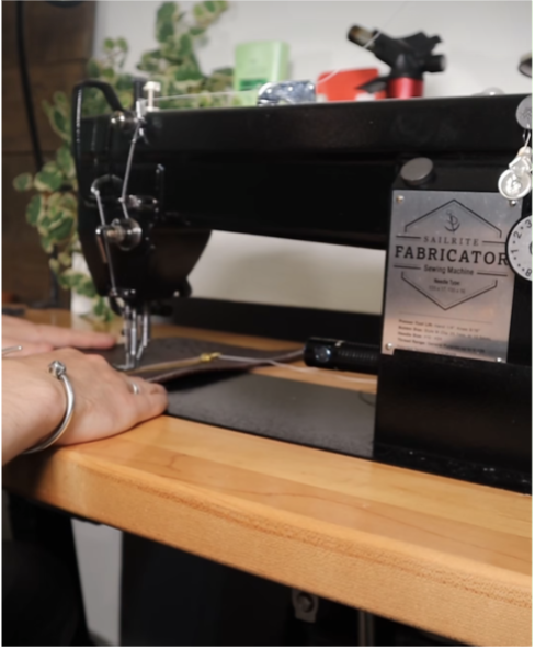 Chris using his Fabricator to sew a zipper into a leather panel.